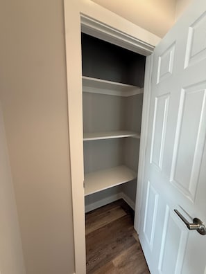 Puerta cerrada con picaporte blanco, suelo de madera y pared blanca.