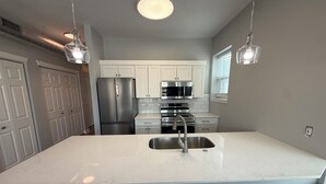 A kitchen with white cabinets, stainless steel appliances, and pendant lighting. - Fully Renovated 1BR  Walk to Hospitals University Parking (Indianapolis)