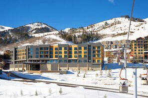A modern hotel with a ski lift in the background. - Canyon Haus 129 | Deluxe Studio | Valley View | Heated Pool | Hot Tub (Park City)