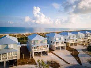A beachfront property with multiple two-story houses featuring balconies and a clear view of the ocean. - Cape San Blas gulf front home with private pool and elevator (Port St. Joe)