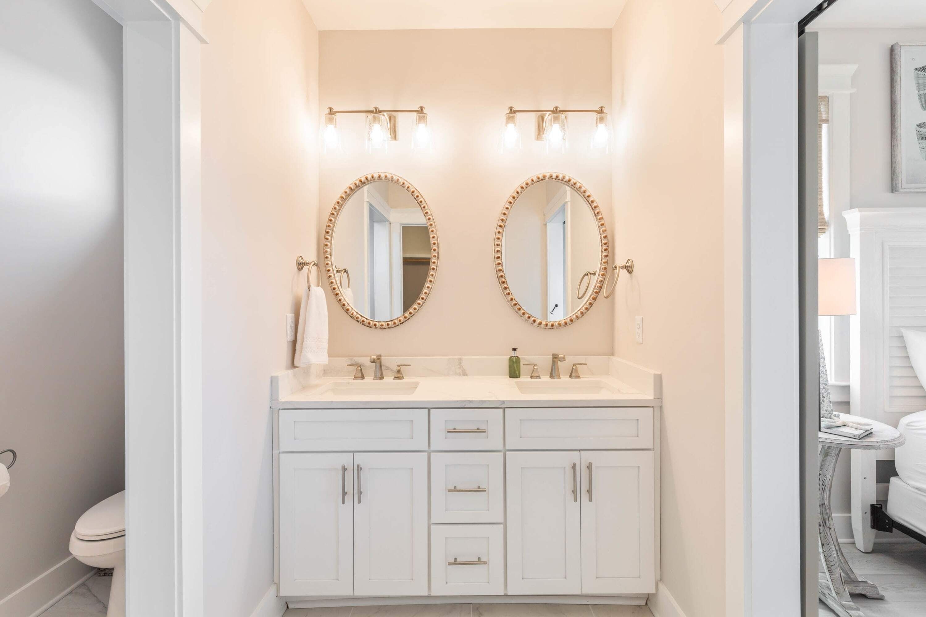 A bathroom with two sinks, a mirror, and a toilet.