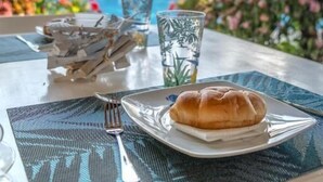Una mesa de comedor con un plato de comida, un vaso de agua y un tenedor.