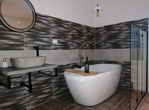 A modern bathroom with a freestanding bathtub, a vessel sink, and a large mirror. - Apartment Penthouse Ivan (Drnis)