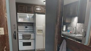 A kitchen with a microwave, oven, and refrigerator. - Ellis Kansas Lakehouse (Ellis)