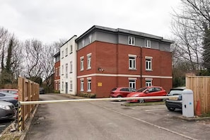 A multi-story residential building with a gated parking area.