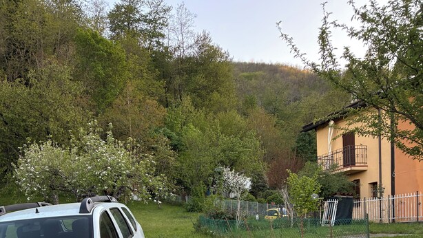 A white SUV parked near a rustic wooden sign indicating 'Il Picchio Parking.' - Apartment in the midst of nature that will help regenerate your body and mind (Castiglione dei Pepoli)