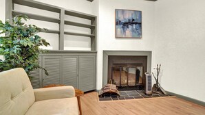 A living room with a fireplace, a sofa, a plant, and a painting on the wall. - NEW Downtown York 2B Getaway. Modern Comfort. (York)