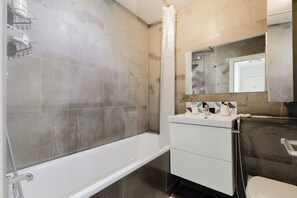 A bathroom with a bathtub, a sink, and a toilet. - Sunny 1BD Flat in the Heart of Maida Vale (Greater London)