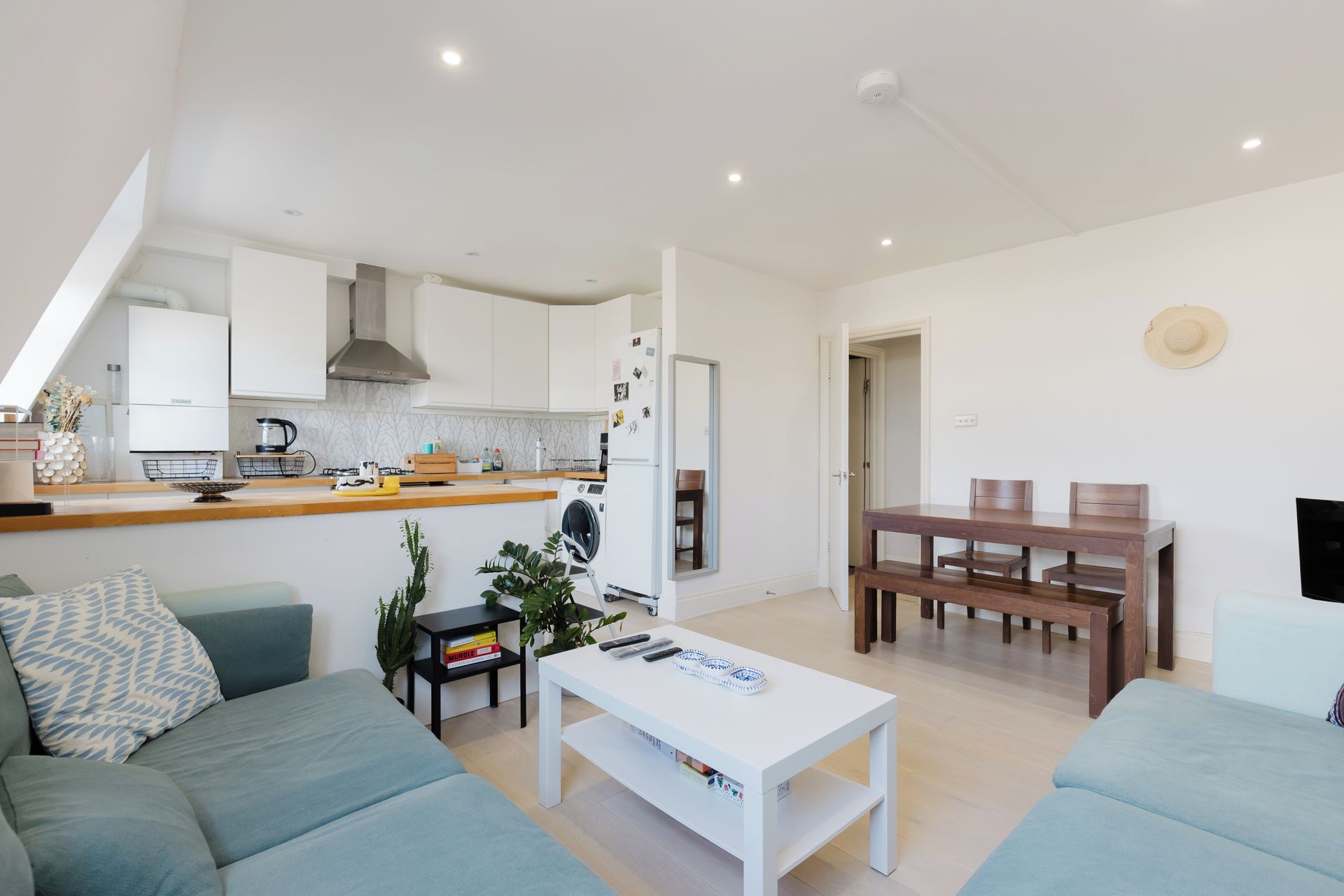 A modern apartment with a living room, dining area, and kitchen.