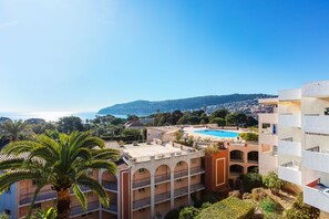 A hotel with a rooftop pool, multiple balconies, and a view of the sea and hills. - ANGE GARDIEN VI AP4502 By Riviera Holiday Homes (Villefranche-sur-Mer)