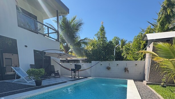 A swimming pool with lounge chairs, a barbecue area, and a modern house in the background. - Surf City Beach House with Private Pool – 5-10 Min Walk to Beach, Near El Tunco (Playa San Blas)
