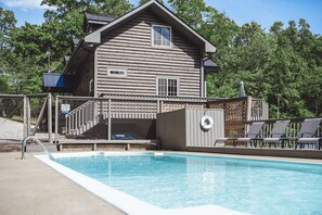 A log cabin with a swimming pool, a lifebuoy, and a covered seating area. - Scotts Creek Cabins - Hem Loch (Logan)