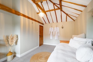 A bedroom with a wooden ceiling, a bed with white bedding, a woven rug, and a vase with pampas grass. - The Cottage at Tuffon Hall, Sible Hedingham, Suffolk (Sible Hedingham)
