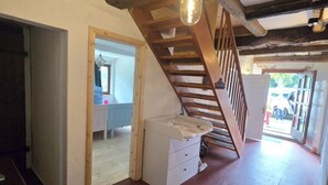 A rustic interior with exposed wooden beams, a staircase, and a light fixture. - David & Marion's Vacation Rental: 7 minutes from Karls Erlebnisdorf/Bremerhaven and the Weser beach. (Loxstedt)