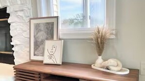 A wooden console table with a framed picture and decorative vase, positioned near a window with a view. - Good Vibes LKA Lakeview with Boat Slip (Orange)