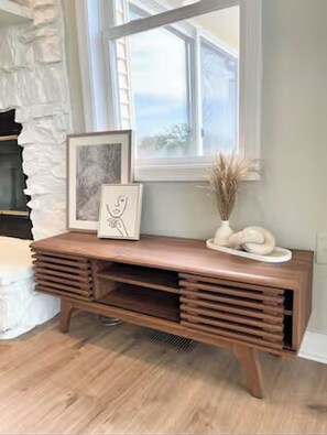 A wooden console table with a framed picture and decorative vase, positioned near a window with a view. - Good Vibes LKA Lakeview with Boat Slip (Orange)
