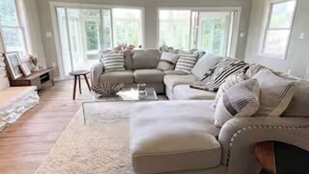 A spacious living room with a large sectional sofa, a ceiling fan, and large windows. - Good Vibes LKA Lakeview with Boat Slip (Orange)