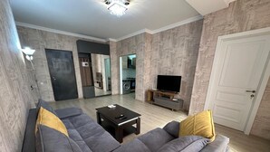 A modern living room with a sectional sofa, a coffee table, and a television.