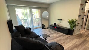 Una sala moderna con un sofá, una mesa de centro y un televisor.