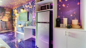 A modern kitchen with a refrigerator, microwave, and a decorative wall with floating lanterns. - Rapunzel themed studio w/ pool & workspace (Kissimmee)