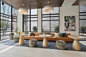 A modern interior with a sofa, round tables, and large windows. - Spacious and Perfect for Extended Stays - Sleeps 8 (Charleston)