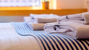 A neatly made bed with folded towels and a striped blanket. - ihTop | 4 Bedrooms | 3 Bathrooms | 3 Balconies (Espinho)
