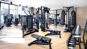 Ein Fitnessraum mit Trainingsgeräten, Bänken und Kurzhanteln.