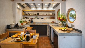 A kitchen with a wooden table, chairs, a stove, and a sink.