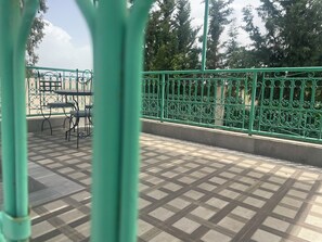 A green metal railing, a tiled floor, and a table with chairs. - Spacious 3-bedroom villa in peaceful 20min Marrakech (Ouled Rahou)