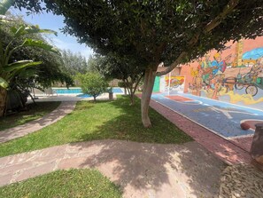 A courtyard with a swimming pool, a mural, and a basketball court. - Spacious 3-bedroom villa in peaceful 20min Marrakech (Ouled Rahou)