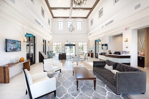 A spacious lobby with a high ceiling, a chandelier, and a Game Room sign. - NEW!Racing Simulator|Game Room|Movie Room|Sleep 21 (Kissimmee)