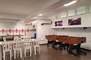 A room with tables and chairs, air conditioning units, and two foosball tables. - Oceanfront 2-BR in Marbella  Private Beach + View (Playa Juan Dolio)