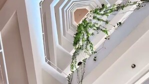 Et mere etagers indre med hvide vægge og en central spiraltrappe.