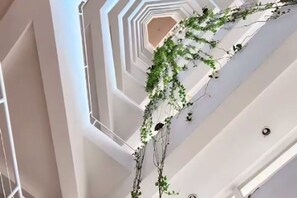 A multi-level interior with white walls and a central spiral staircase. - Oceanfront 2-BR in Marbella  Private Beach + View (Playa Juan Dolio)