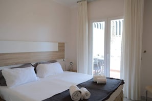 A hotel room with a bed, a headboard, a window with curtains, and a view of an outdoor area. - Sea front apartment in Playa Rocio, Puerto Banus with swimming pool and parking (Marbella)