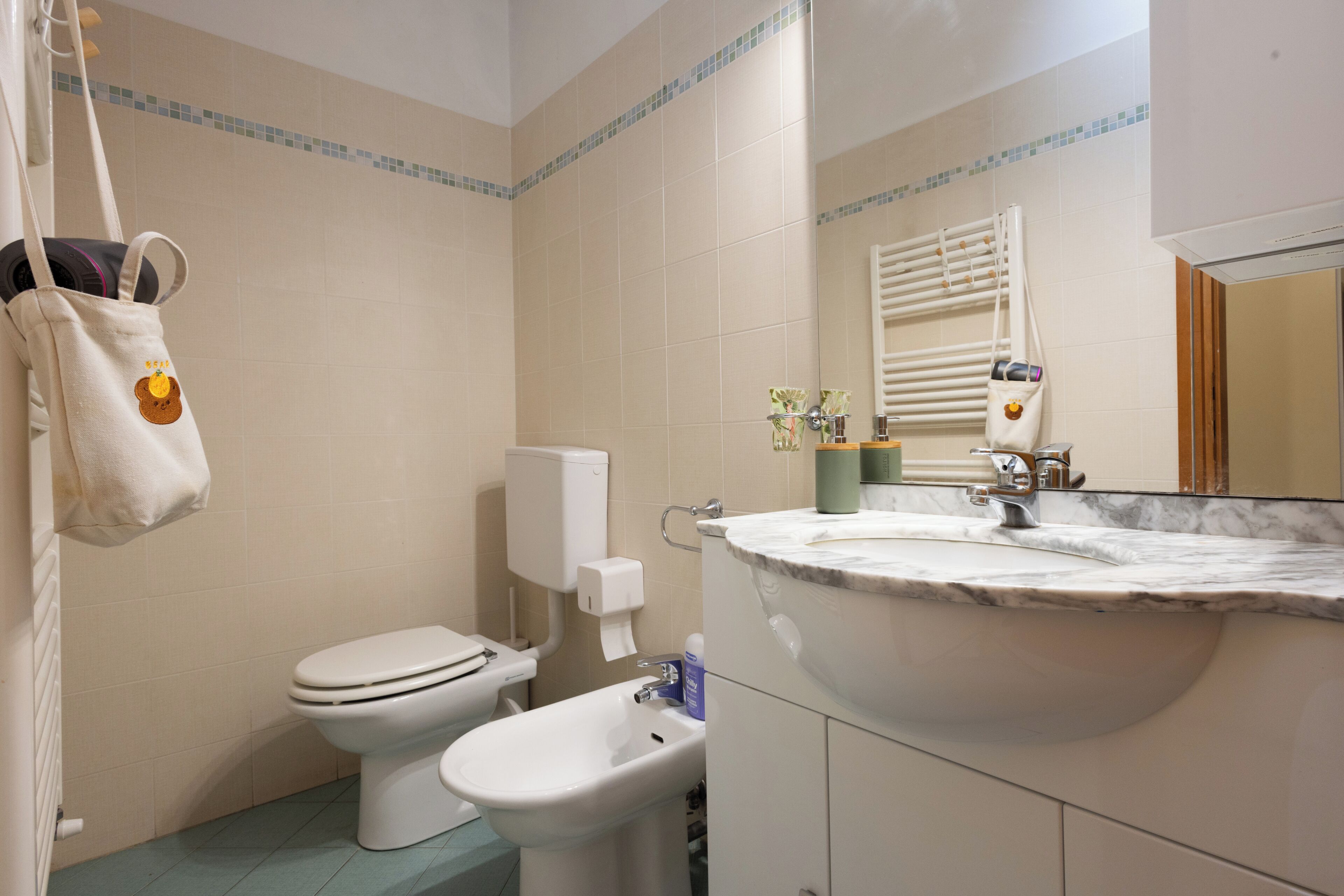 A bathroom with a toilet, bidet, and sink.