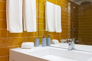 A bathroom with a white sink, chrome fixtures, and a mirror. - Moderno de 2 dorm. con balcón en Campo Alegre (Porto)