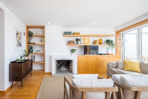 Ein modernes Wohnzimmer mit Kamin, Holzmöbeln und einem Fernseher.
