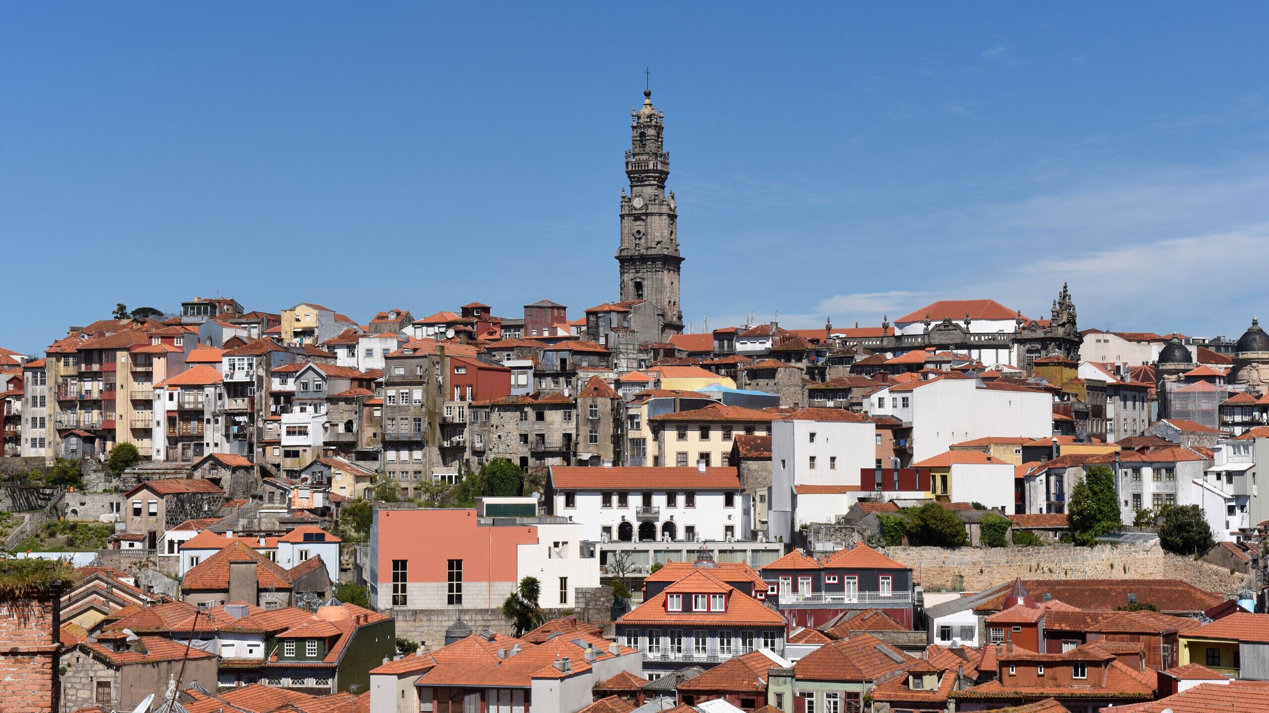 A historic town with a prominent tower, dense buildings, and red-tiled roofs.