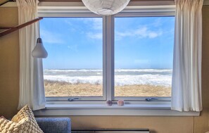 A room with a large window overlooking a beach, a lamp, and a cushion. - Gorgeous home in Hjørring with house sea view (Hjørring)