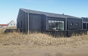Un edificio moderno con techo inclinado, ventanas grandes y fachada de metal.