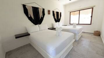 A hotel room with two beds, a ceiling fan, and a large window.