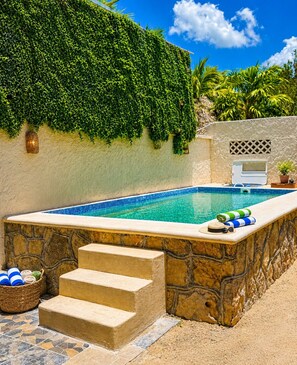 Una piscina al aire libre, tumbonas