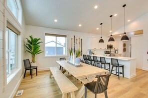 A spacious kitchen with a central island, pendant lights, and a large window. - Lake House Sleeps 16 with Views and Amenities (Garden City)