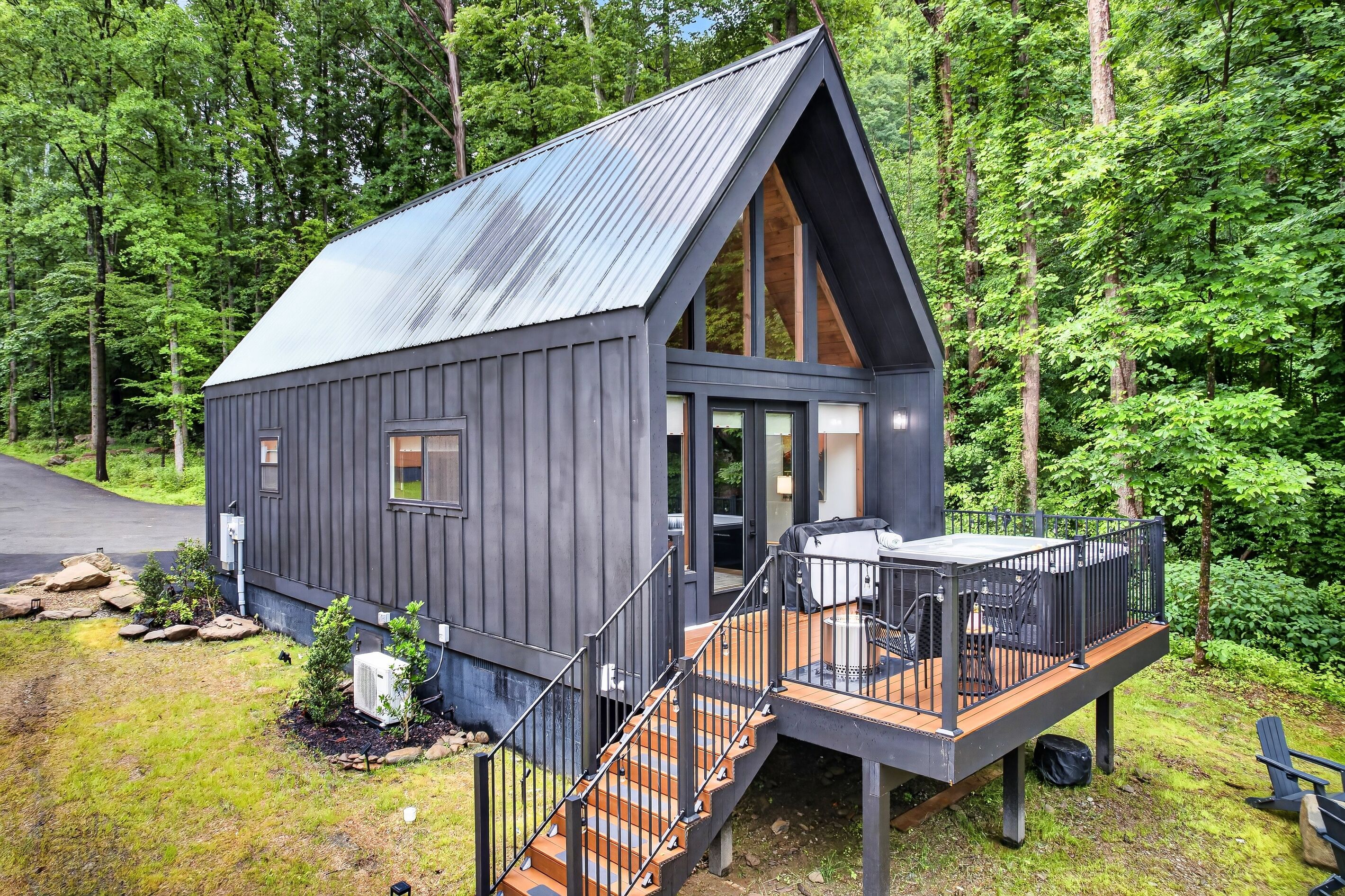 A cabin with a deck, a staircase, and a large window.