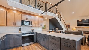 A modern kitchen with a built-in oven, microwave, and a dining area with a fireplace.