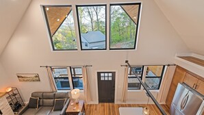 Un ampio loft con soffitto alto, ampie finestre, un'accogliente zona salotto e una cucina moderna.
