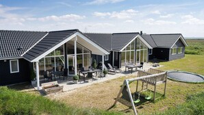 En rad moderna hus med stora fönster och en uteplats.