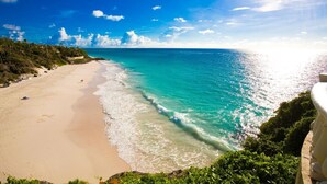 A beach with clear turquoise water, a sandy shore, and lush greenery. - A beautifully appointed 2-bdrm, 2-bath resort villa atop Barbados’ most celebrated cliffside, w/ panoramic ocean views & designer interiors. Dedicated concierge service & complimentary airport transfers. (St. Philip)