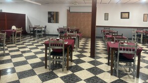 A restaurant with checkered flooring, wooden chairs, and tables. - HOTEL RESTAURANTE LA BARCA (Pedro Munoz)